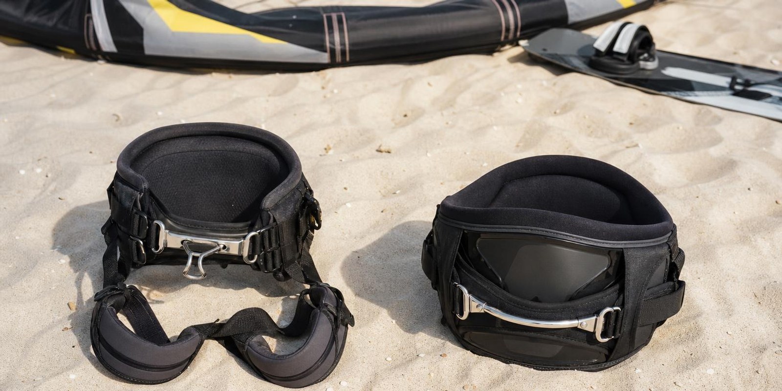 Sitztrapez und Huefttrapez liegen zum Vergleich nebeneinander im hellen Sand.