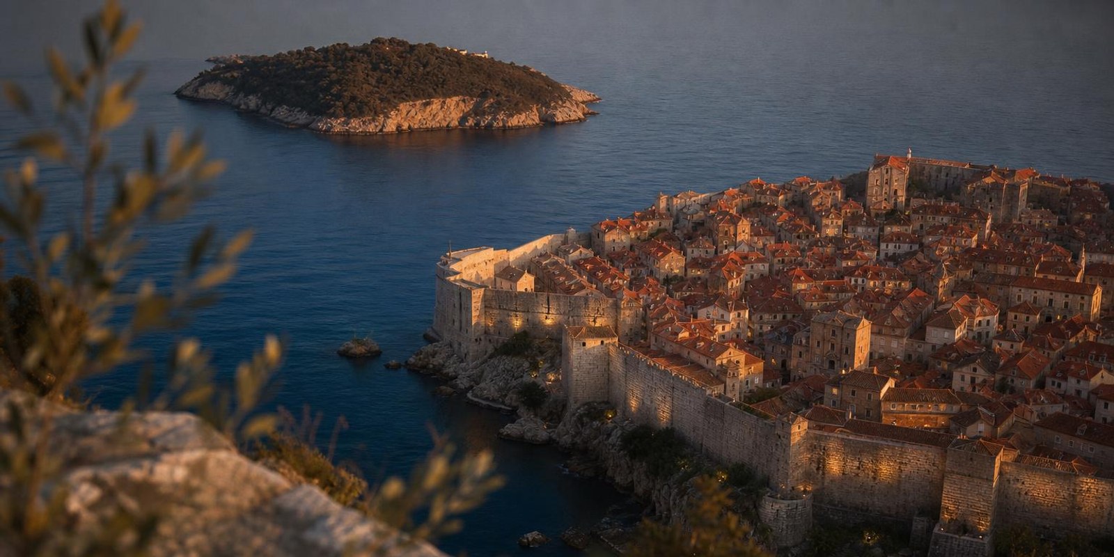 Festungsstadt Dubrovnik mit Ziegeldaechern und Stadtmauer am Abend ueber der Adria.